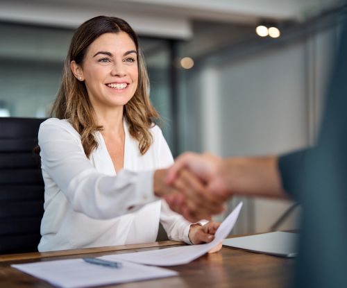 Happy mid aged business woman manager handshaking at office meeting. Happy mid aged business woman manager handshaking at office meeting. Smiling female hr hiring recruit at job interview, bank or insurance agent, lawyer making contract deal with client at work.